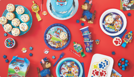 Tabletop with Paw Patrol-themed party favours, décor, and tableware.