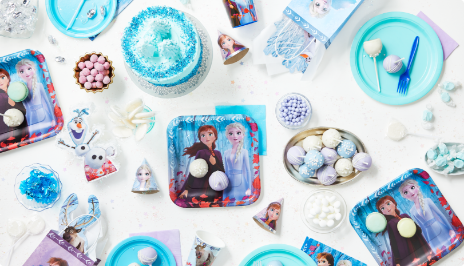 Tabletop with Frozen-themed party favours, décor, and tableware
