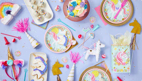 Tabletop with Unicorn-themed party favours, décor, and tableware.