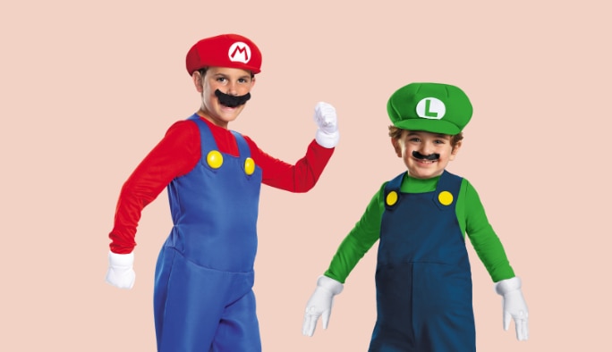 Un enfant portant un costume de Super Mario avec un enfant portant un costume de Luigi.