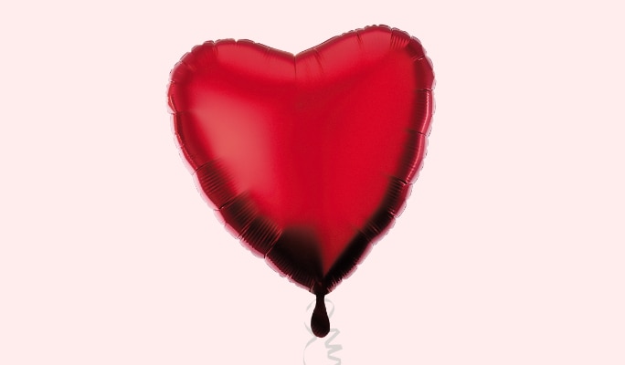 A red heart-shaped foil balloon.