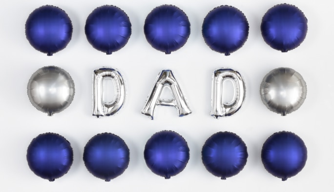 Ballons en aluminium argentés en lettres D-A-D entourés de ballons ronds en aluminium bleus et argentés.