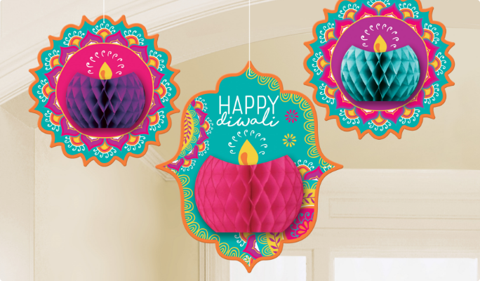 A set of three teal, pink and purple Diwali honeycomb decorations hanging from a ceiling.