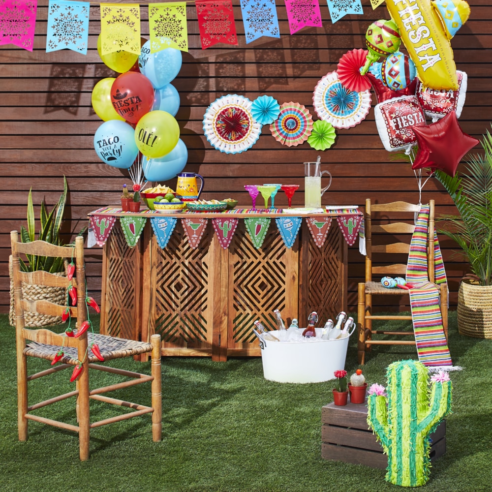 Décorations de fête en plein air avec ballons, banderoles et autres articles de table.