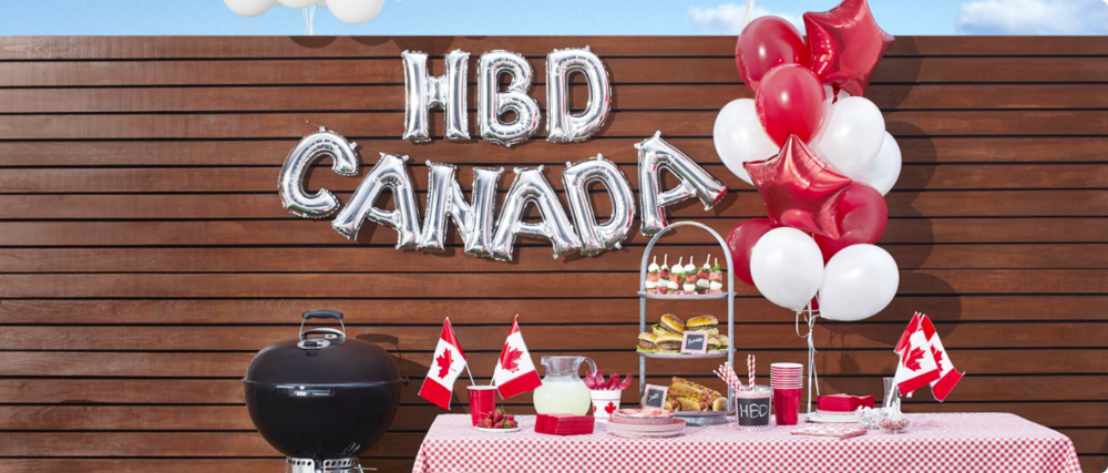 Une terrasse décorée avec une guirlande de ballons argentés en aluminium « HBD Canada », des drapeaux miniatures du Canada et des ballons rouges et blancs.