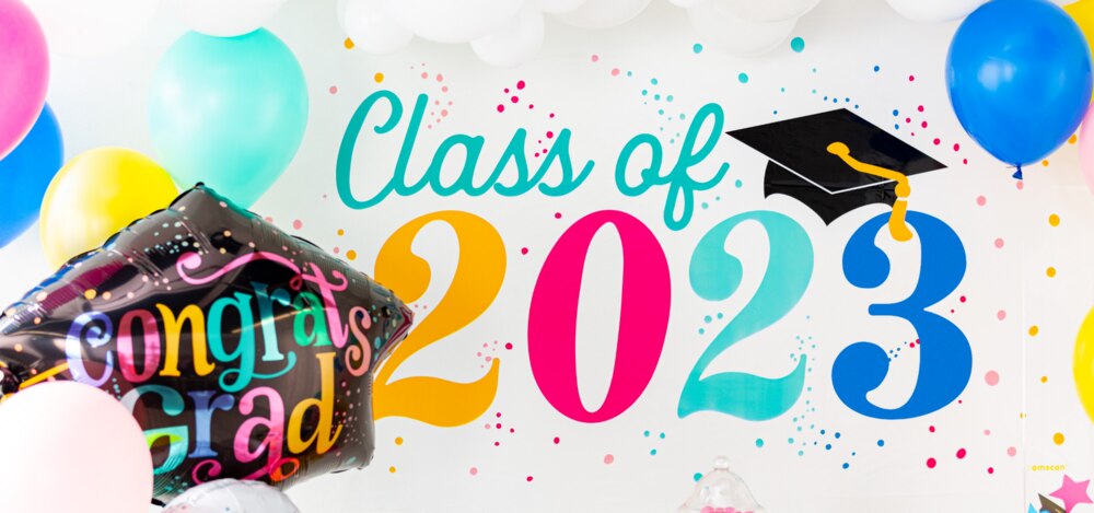 A Follow Your Dreams 2023 large horizontal banner surrounded by multicoloured graduation balloons.