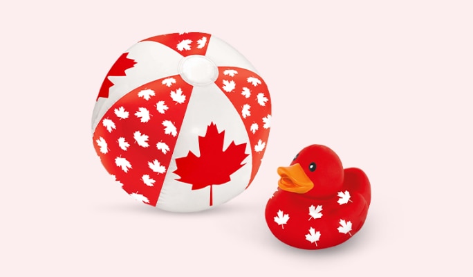 A red and white maple leaf print beach ball and a red Canadian maple leaf rubber duck.