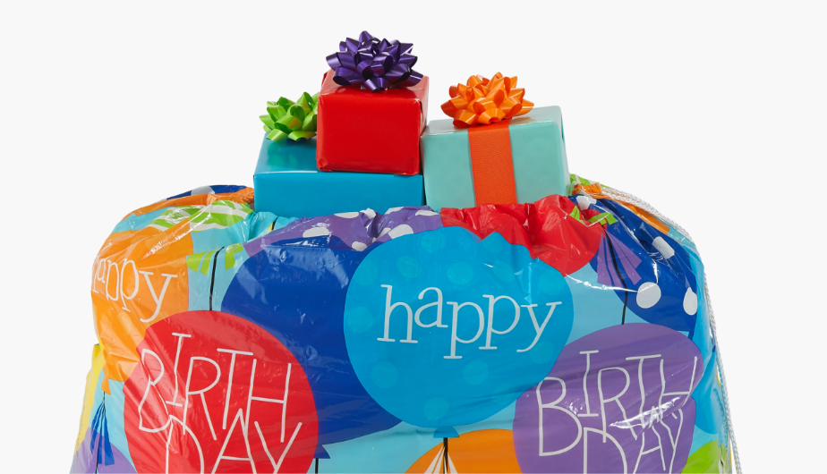 Gifts wrapped in birthday wrapping paper and bows of assorted colours.