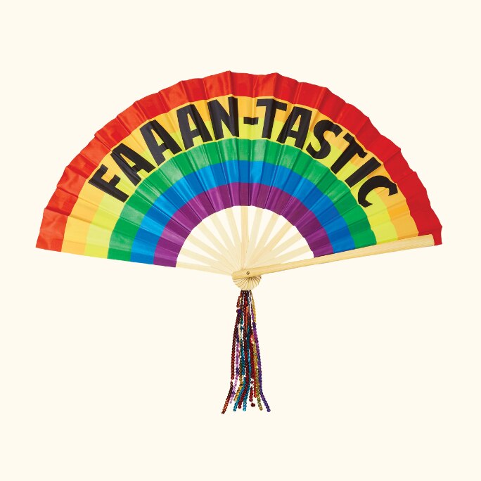 A Pride rainbow handheld fan with a “faaan-tastic” print and a beaded tassel.