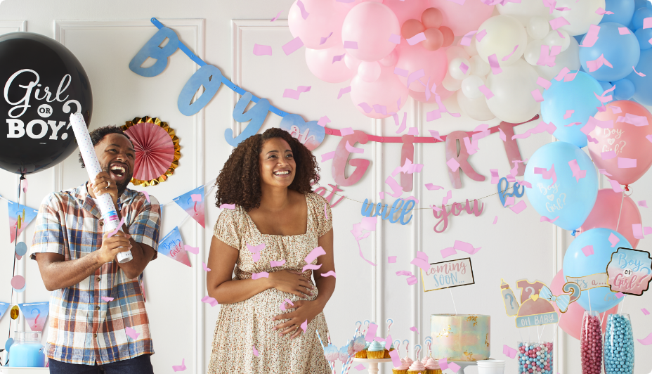 Couple celebrating a gender reveal with people in the background.