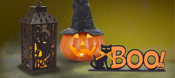 A flickering flame led lantern and a battery-operated light-up plastic pumpkin with a witch hat.