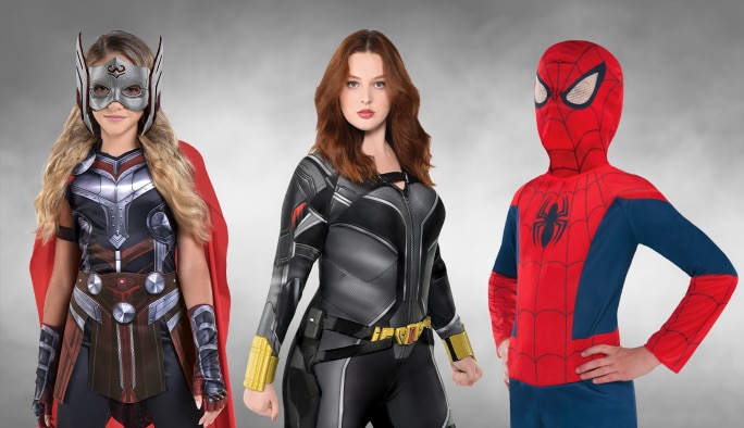Une fille portant un costume Thor, une femme portant un costume de la Veuve noire et un enfant portant un costume Spider-Man.