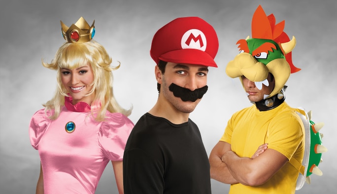 Trois adultes portant des costumes de personnages Super Mario.