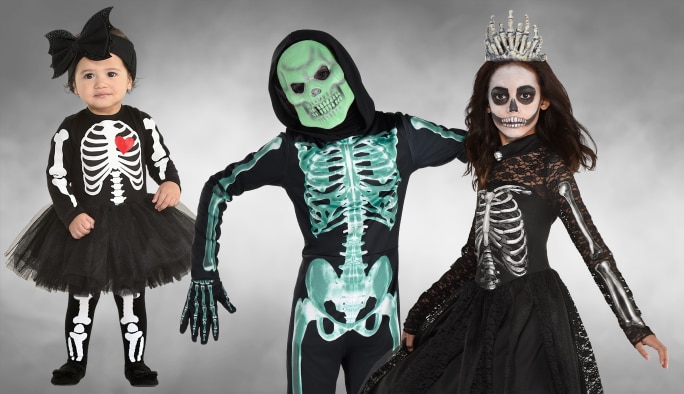 A toddler and two adults wearing assorted skeleton costumes, makeup and accessories.