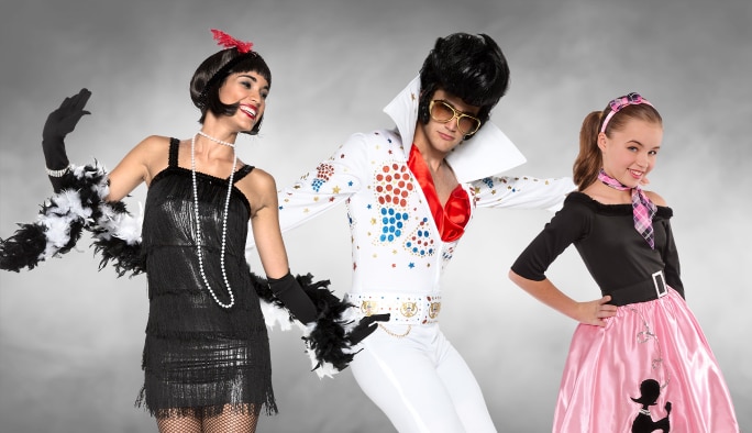 A woman in a flapper costume, a man in a 1970s Elvis costume and a girl in a 1950’s poodle skirt costume.