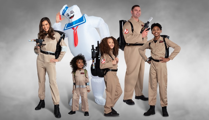 Trois enfants et deux adultes portant des costumes SOS Fantômes et un adulte portant un costume gonflable de Bibendum Chamallow.