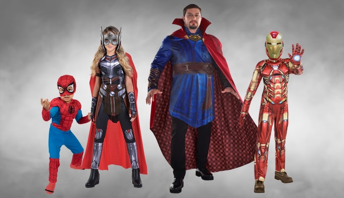Deux adultes et deux enfants portant des costumes de superhéros Marvel.