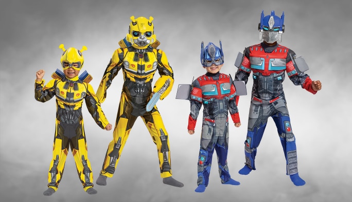 Deux adultes et deux enfants portant des costumes Transformers BumbleBee et Optimus Prime.