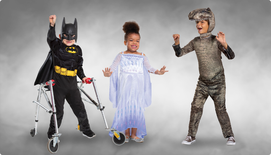 Trois enfants, l’un d’eux portant un costume d’Halloween inclusive et utilisant un cadre de marche.