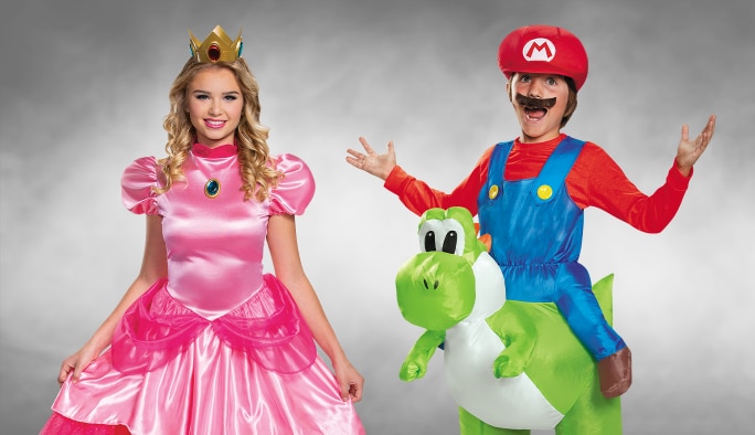 Une femme portant un costume de la Princesse Peach et un garçon portant un costume de Mario assis sur Yoshi.