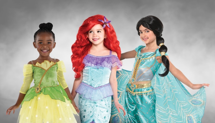 Une fille portant un costume de Tiana, une fille portant un costume d’Ariel et une fille portant un costume de Jasmine.