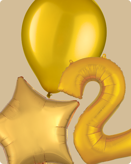 Un ballon doré en forme du chiffre 2 entouré de ballons ronds et de ballons en forme d’étoiles.