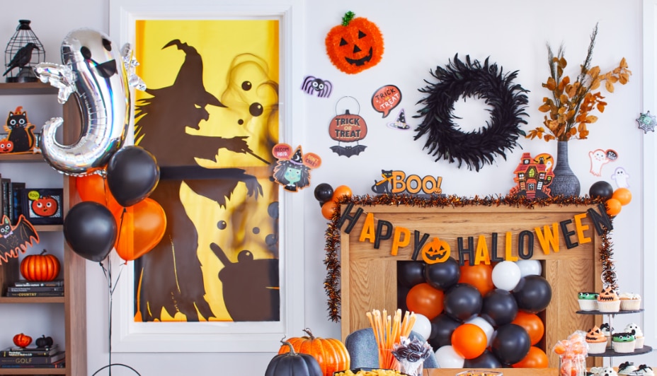 A living room decorated with black and orange balloons and Halloween decor.