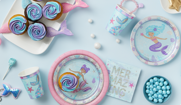 Iridescent Shimmering Mermaids plates, cups and napkins on a table with various treats.