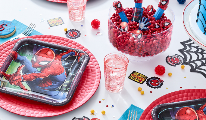 Une assiette en papier Spider-Man de Marvel sur une table avec des articles de fête thématiques.