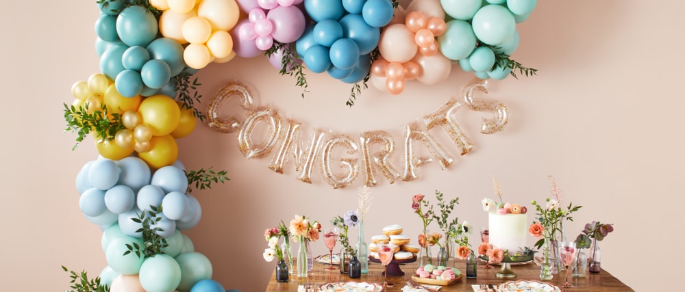 A multi-coloured balloon arch and a congrats letter balloon. 