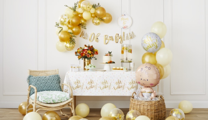 Un bouquet de ballons dorés et blancs et une guirlande de ballons et un plancher rempli de ballons dorés.