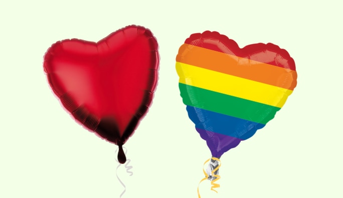 A red heart and a rainbow heart balloon.