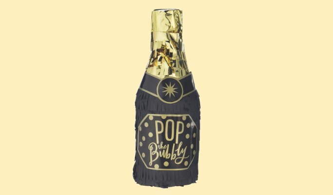A black and gold champagne bottle prop with a label that reads "POP the Bubbly".