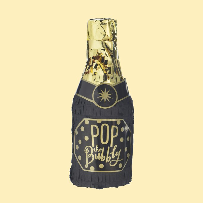 A black and gold champagne bottle prop with a label that reads "POP the Bubbly".