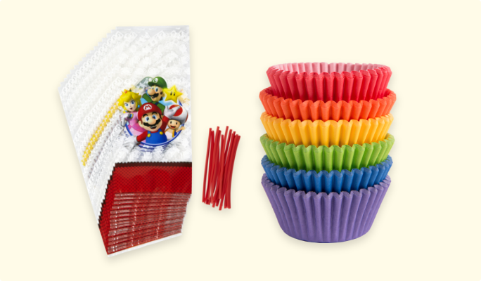Super Mario-themed treat bags and a stack of rainbow paper baking cups.