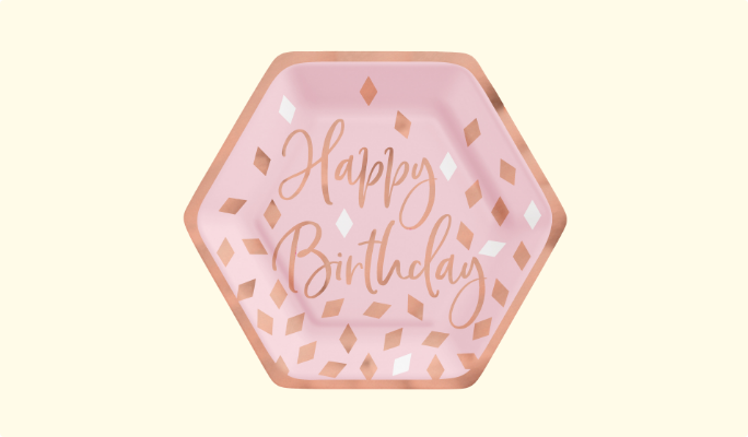 A hexagonal paper plate featuring a "Happy Birthday" message on a pink background with gold confetti and a gold border.