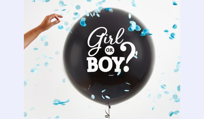 A hand popping a black balloon featuring a "girl or boy" message.