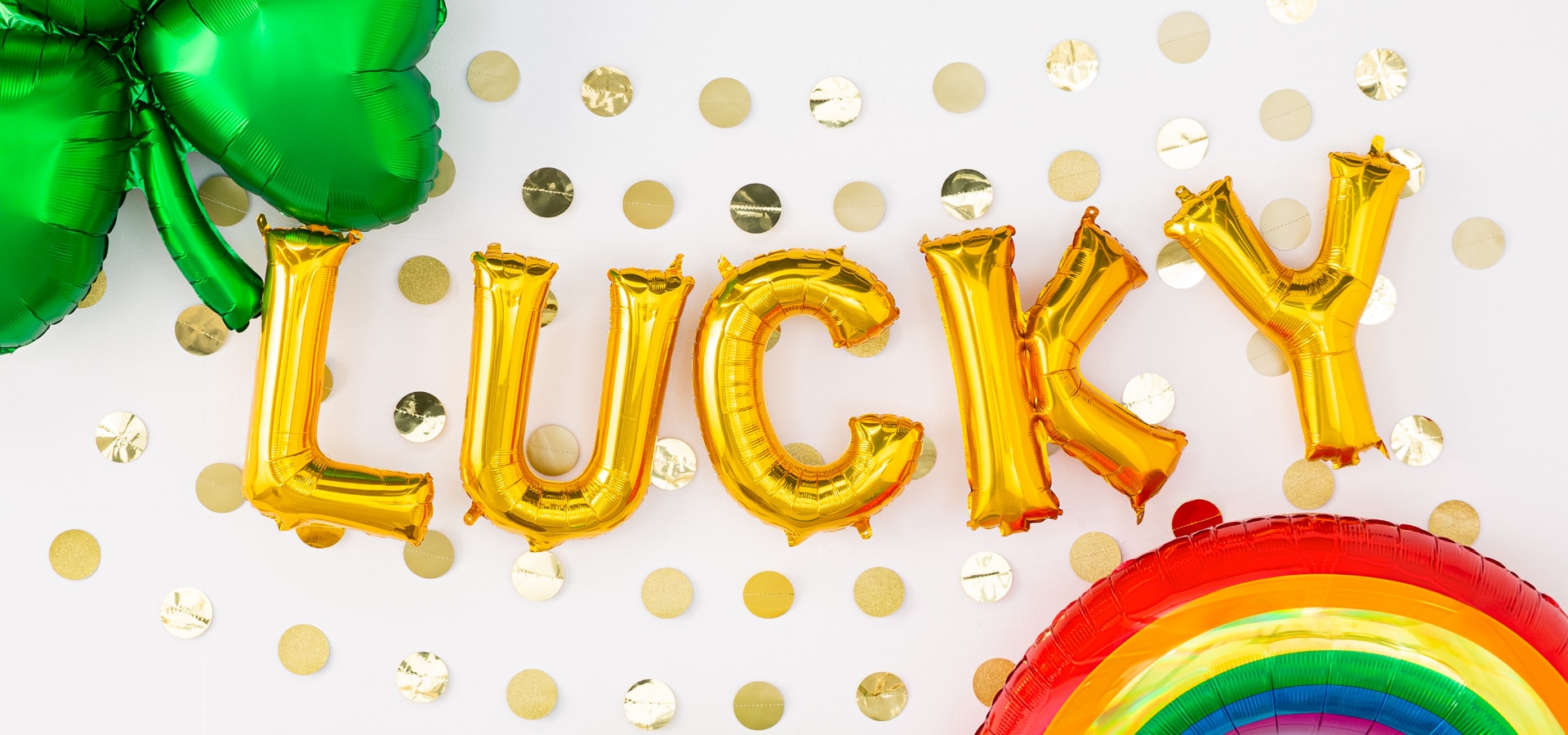 Ballons dorés en forme de lettres épelant « Lucky », un ballon en aluminium vert en forme de trèfle et un ballon en forme d’arc-en-ciel.