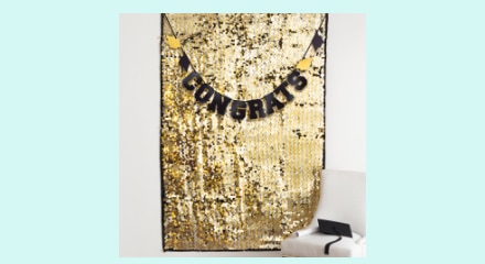 A gold curtain backdrop and a banner with a "CONGRATS" message.