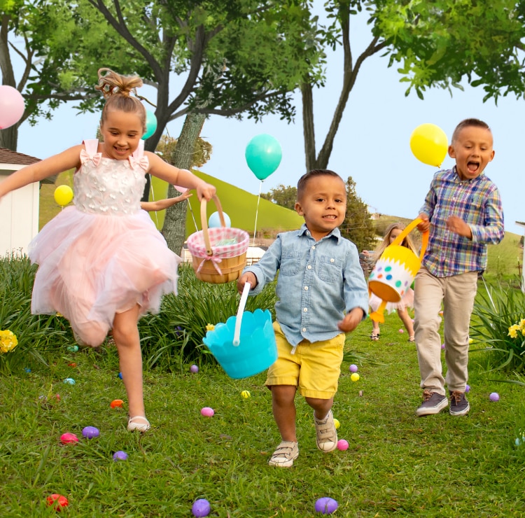 A group of children running outside holding Easter baskets looking for Easter eggs.