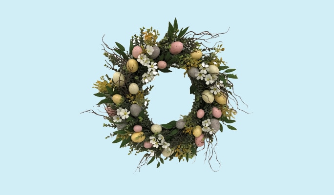 A wreath decorated with pastel coloured eggs and flowers.