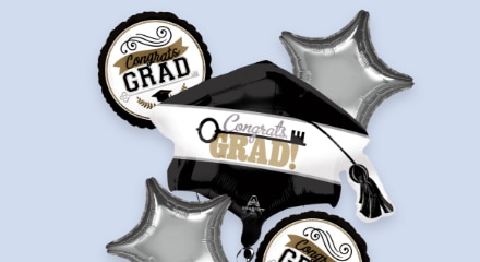 A bouquet of black, silver and gold graduation balloons.