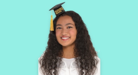 A young woman wearing a mini graduation cap.