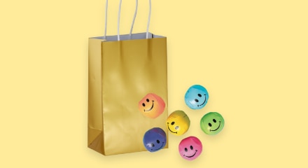 A gold gift bag with smiley face favours.