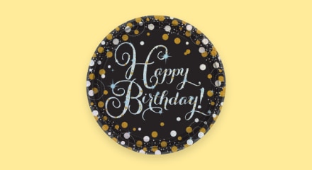 A black and gold-patterned plate that reads 'Happy Birthday!'.