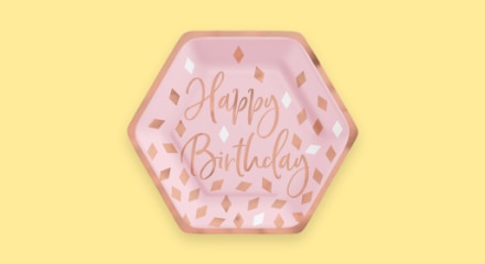 Une assiette hexagonale rose avec les mots « Happy Birthday ».
