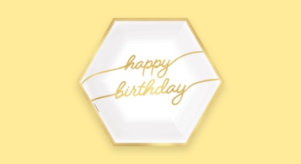 Une assiette hexagonale blanche et dorée avec les mots « HAPPY BIRTHDAY ».