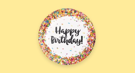 A sprinkle patterned plate that reads 'Happy Birthday!'