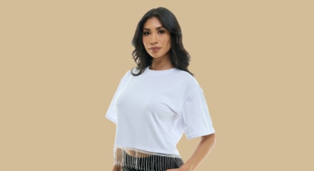 A woman wearing a white cropped shirt and black shorts.