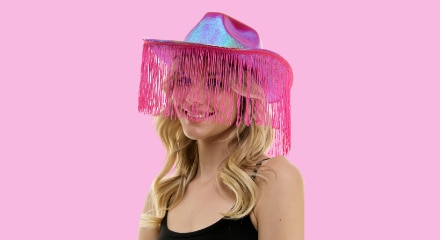 A woman wearing a pink fringe cowgirl hat.